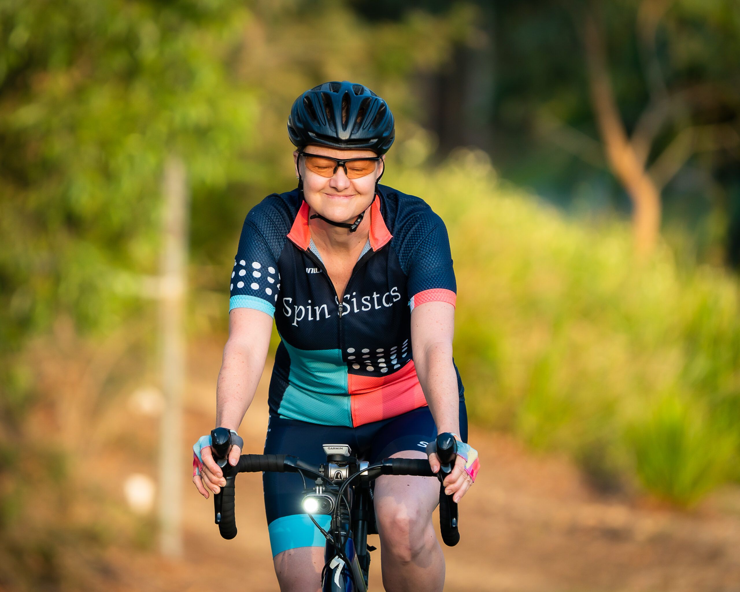 Portrait of a smiling Spin Sistas cyclist on her bike