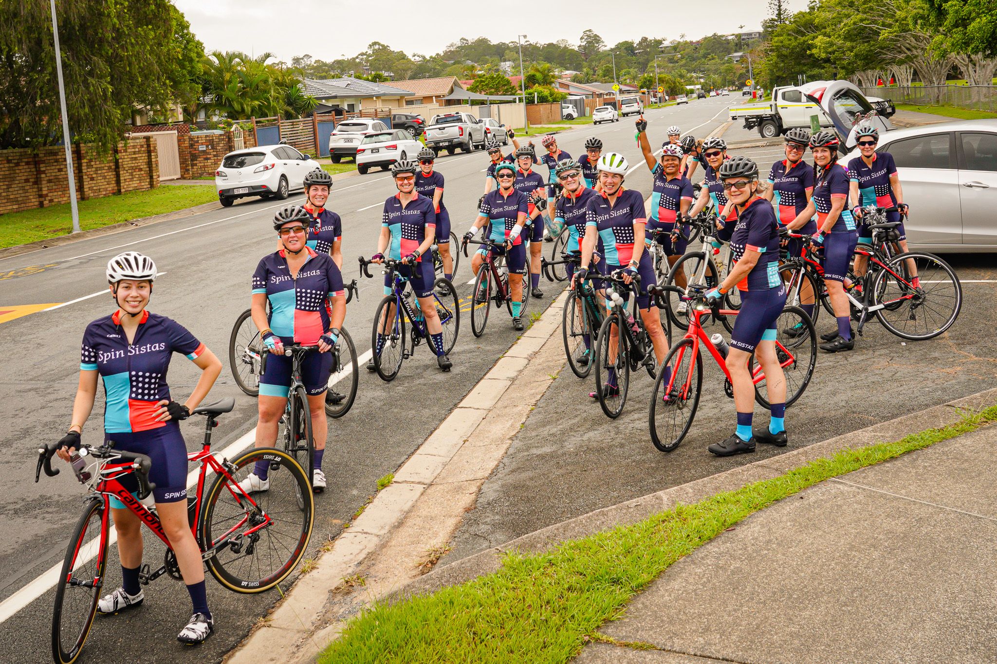 A large group of Spin Sistas standing with their bikes